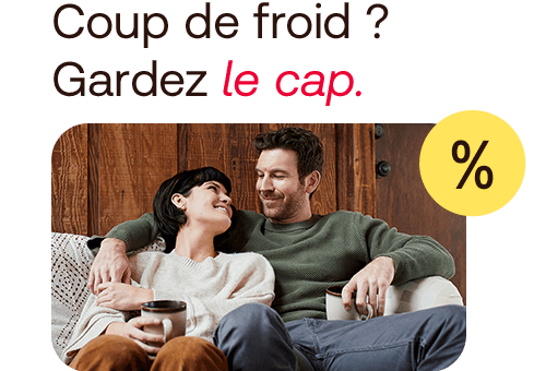 A couple sitting on the sofa drinking tea and smiling at each other.