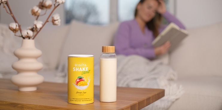Table avec un shake BEAVITA et une femme en arrière-plan.